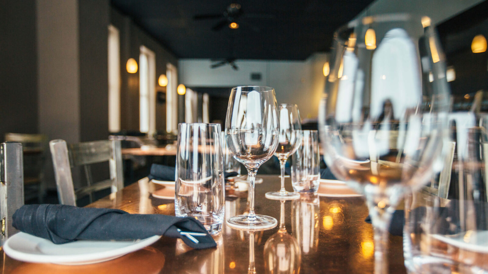 A restaurant table waiting to be seated with guests near the wine bar at The Landing in British Columbia