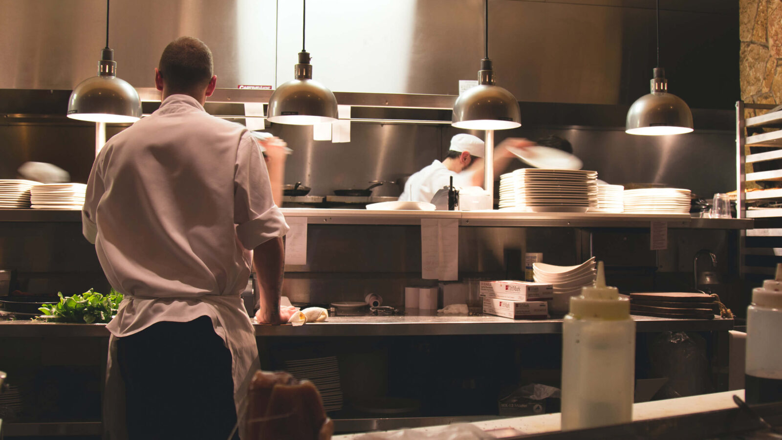 Line cooks working during a dinner rush at a steak and seafood restaurant known for amazing food and using metric and imperial units