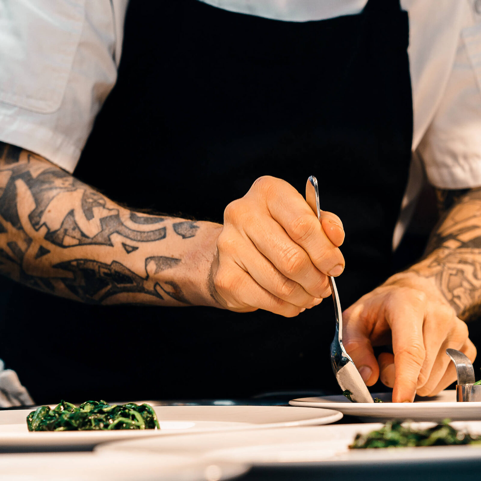 A chef preparing appetizer plates (small bites) of good food with local ingredients and seasonal Okanagan flavours in a fine dining restaurant